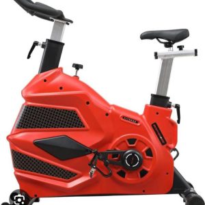 Large red commercial spinning fitness bike with a covered flywheel, side view — Electromart Uganda