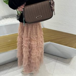 A woman carrying the brown pleated slim crossbody bag over a tulle skirt — Electromart Uganda