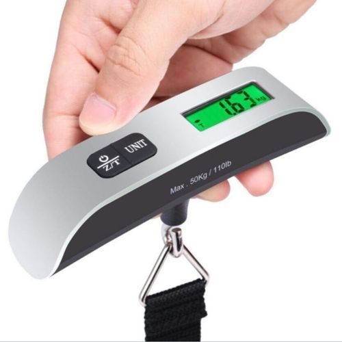 Handheld digital luggage scale with a backlit display and hook strap, in use — Electromart Uganda