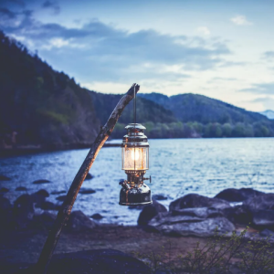 Vintage pressure kerosene lantern glowing, hanging over a lake at dusk — Electromart Uganda